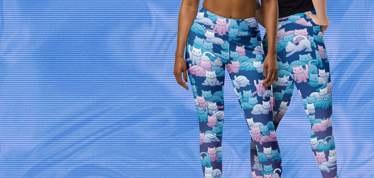 A pair of women's leggings with the new Y2K Camo Cats pattern, modeled on women against a dreamy blue background.